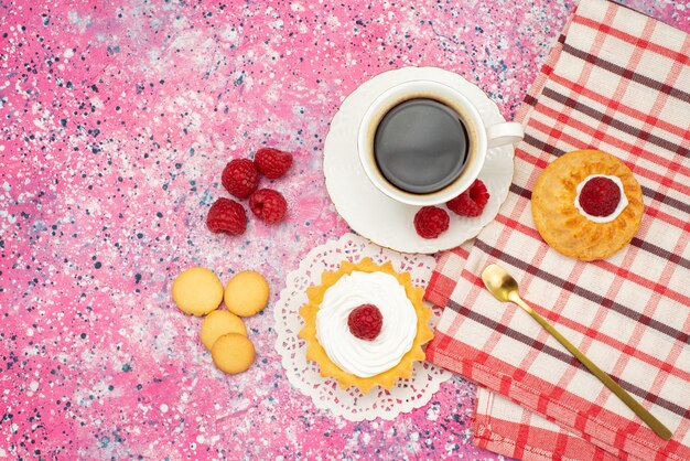 Top distante vista piccola torta con biscotti alla crema lamponi freschi con tazza di caffè sul colore del tè superficie colorata