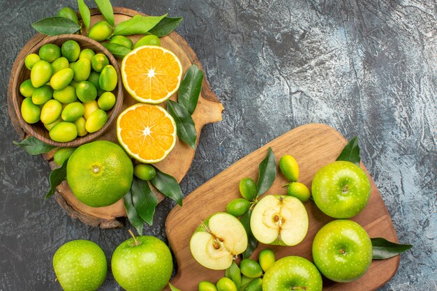 Top vista ravvicinata agrumi agrumi con foglie e mele sulle tavole