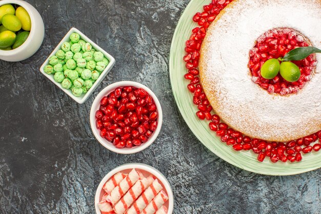 Top vista ravvicinata ciotole di caramelle lime una torta appetitosa sul piatto