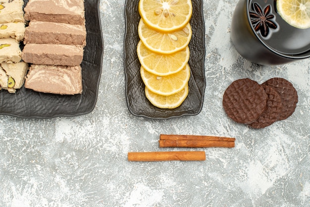 Top vista ravvicinata dolci cannella una tazza di tè al limone semi di girasole halva sul piatto