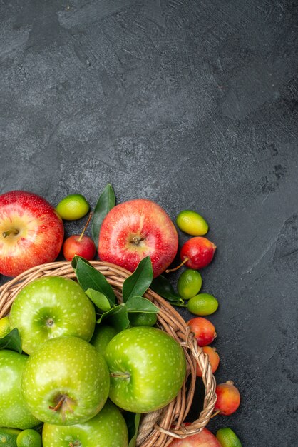 Top vista ravvicinata frutti cesto in legno di mele verdi e mele rosse ciliegie agrumi