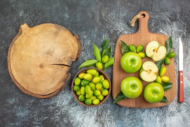 Top vista ravvicinata mele mele con foglie coltello ciotola di agrumi il tagliere