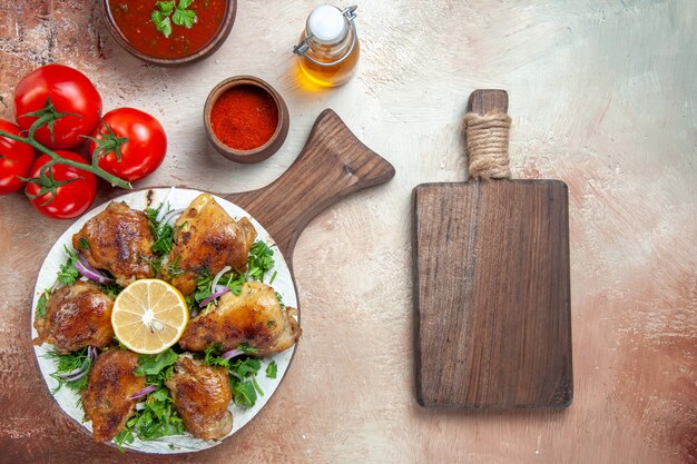 Top vista ravvicinata pollo pollo con erbe salsa di pomodori spezie bottiglia di olio la tavola di legno