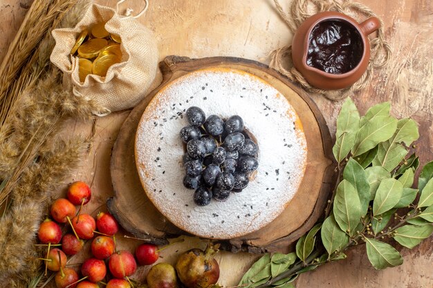 Top vista ravvicinata una torta una torta sul bordo caramelle bacche di cioccolato spighe di grano