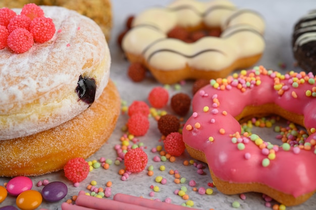 Topping su ciambelle alla fragola e ciambelle bianche. Messa a fuoco selettiva