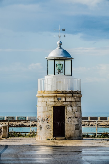 Torre davanti all'acqua sotto un cielo nuvoloso