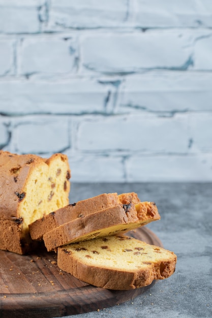 Torta affettata dell'uva sultanina su una tavola di legno rustica.