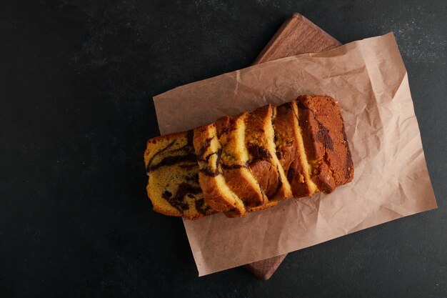 Torta al cacao a fette su un pezzo di carta, vista dall'alto.