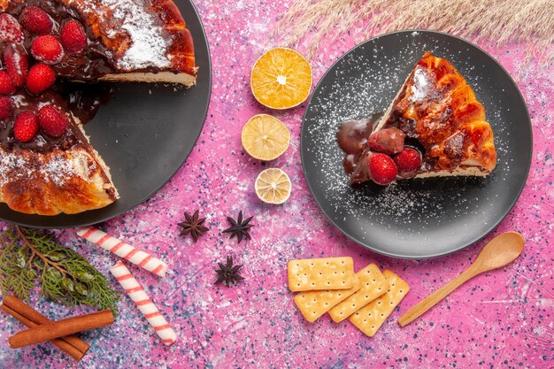 Torta al cioccolato alla fragola vista dall'alto con e cracker sulla superficie rosa