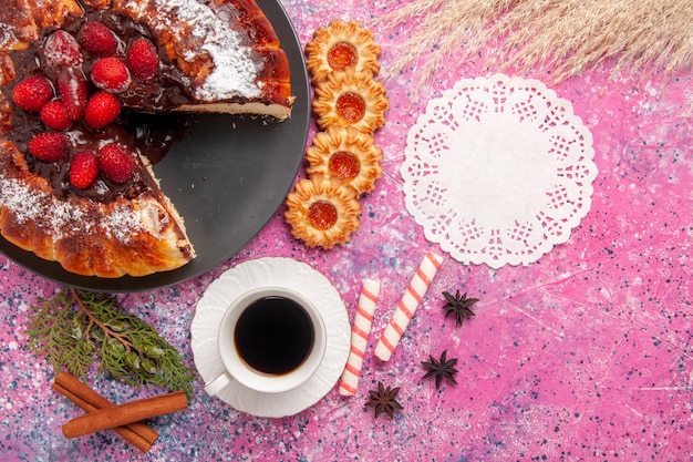 Torta al cioccolato alla fragola vista dall'alto con e tazza di tè sulla superficie rosa chiaro