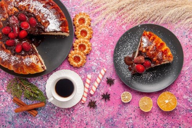 Torta al cioccolato alla fragola vista dall'alto con e tazza di tè sulla superficie rosa