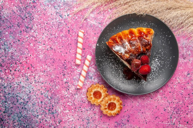 Torta al cioccolato alla fragola vista dall'alto con poco sulla scrivania rosa