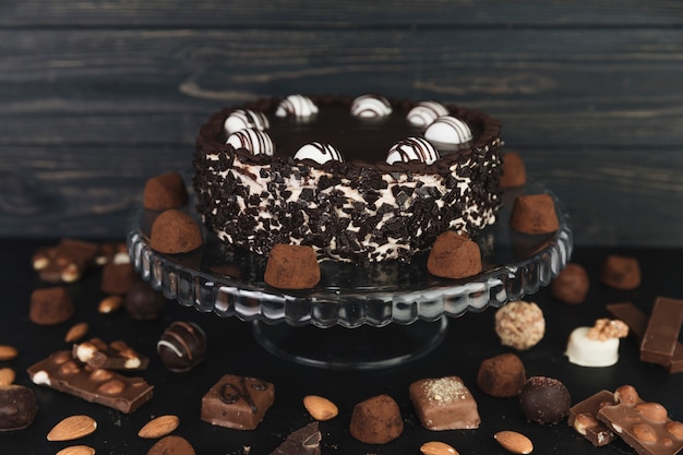 Torta al cioccolato circondata da tartufi al cioccolato e caramelle