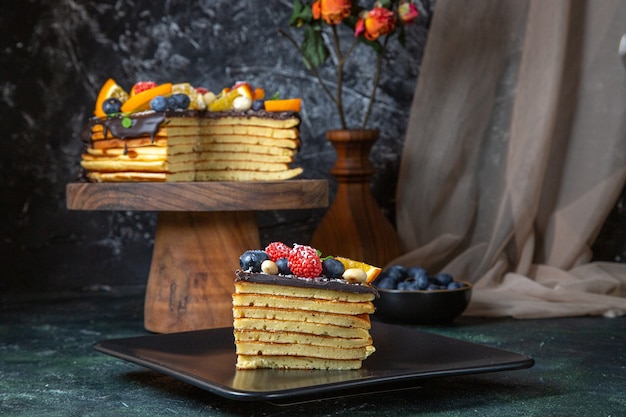 Torta al cioccolato gustosa vista frontale con frutta sulla parete scura