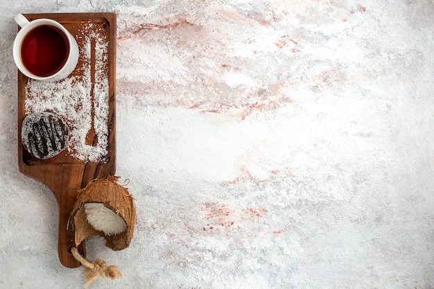 Torta al cioccolato vista dall'alto con la tazza di tè sui biscotti dolci dello zucchero del biscotto della torta di cioccolato della scrivania bianca