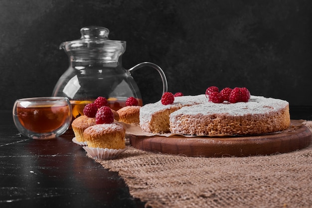 Torta al limone e bevanda sul piatto di legno.