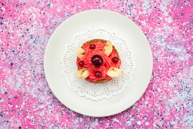 Torta alla crema vista dall'alto all'interno del piatto bianco sullo sfondo colorato biscotto cuocere la torta di colore del tè