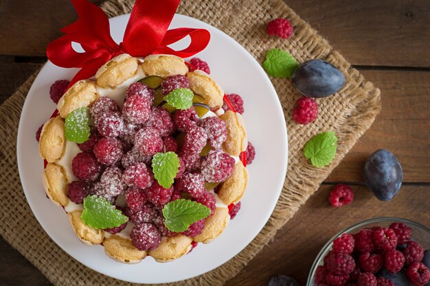 Torta "Charlotte" con lamponi e prugne.