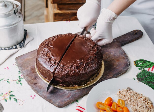 torta choco che viene tagliata squisita deliziosa rotonda intera progettazione con noci kumquat