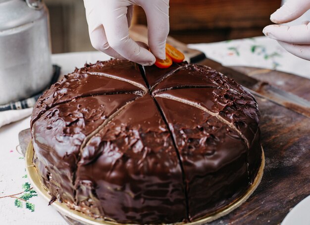 torta choco che viene tagliata squisita deliziosa rotonda intera progettazione con noci kumquat