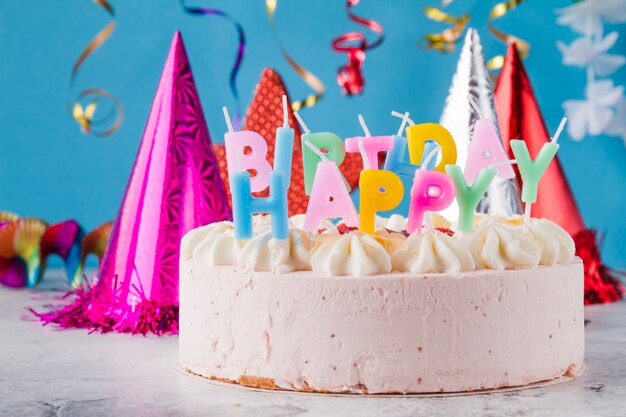 Torta con candele e cappelli di compleanno