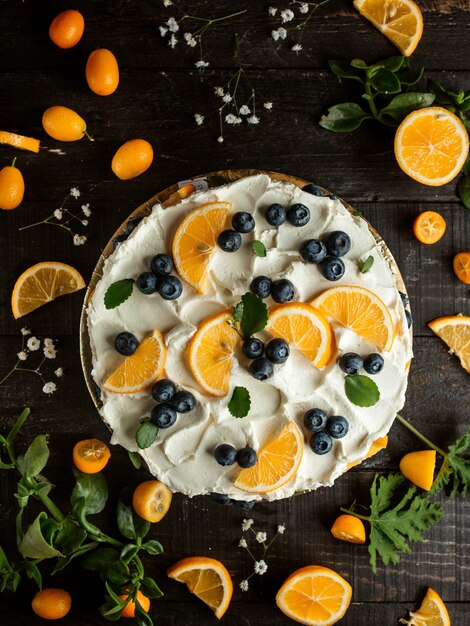 torta con crema di mirtilli kumquat al limone e fiori sul tavolo