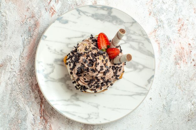 Torta cremosa e deliziosa vista dall'alto con fragole su crema di superficie bianca torta di tè biscotto dolce di compleanno