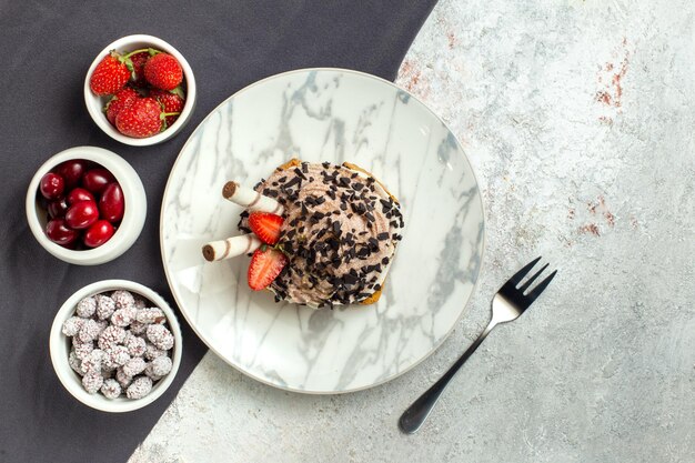 Torta cremosa e deliziosa vista dall'alto con frutta fresca su superficie bianca torta di crema dolce biscotto per il tè di compleanno white