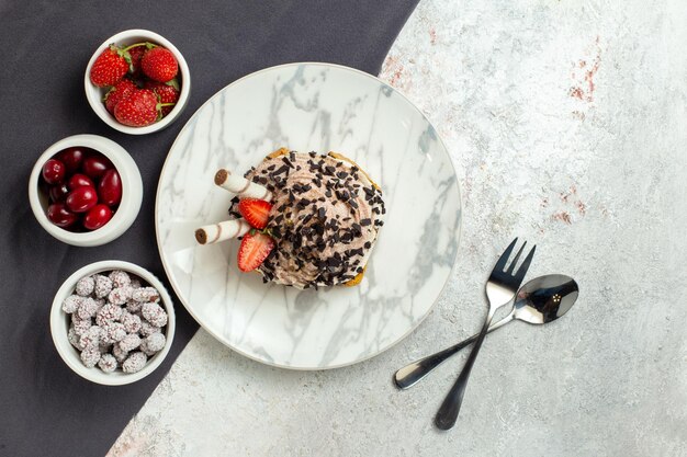 Torta cremosa e deliziosa vista dall'alto con frutta fresca su superficie bianca torta di crema dolce biscotto per il tè di compleanno white