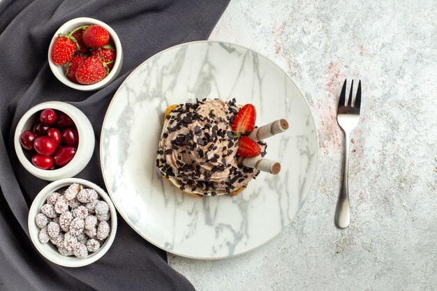 Torta cremosa e deliziosa vista dall'alto con frutta fresca su superficie bianca torta di crema dolce biscotto per il tè di compleanno white