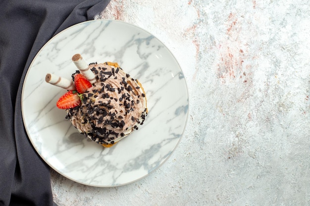 Torta cremosa e deliziosa vista dall'alto su torta di crema dolce biscotto per il tè di compleanno di superficie bianca