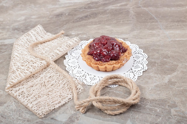 Torta crostata con corda e tela da imballaggio su superficie di marmo.