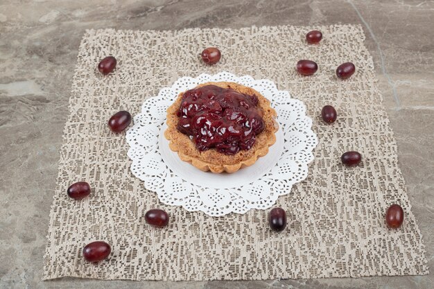 Torta crostata con frutta su tela e uva.