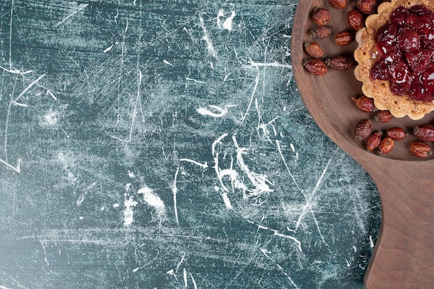 Torta crostata su tavola di legno con cinorrodi secchi. Foto di alta qualità