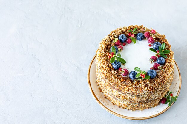 Torta di carote decorata con frutti di bosco e fichi su un piatto bianco. Dolci tradizionali a base di asini.