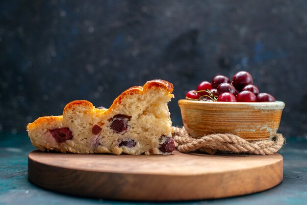 torta di ciliegie affettata insieme a ciliegie acide fresche su torta dolce alla frutta scura