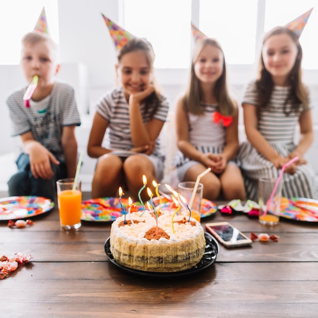 Torta di compleanno vicino ai bambini offuscati