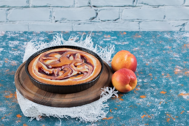 Torta di fragole con pesche fresche intorno.