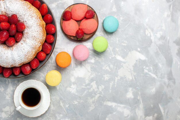 Torta di fragole gustosa vista dall'alto con macarons su bianco