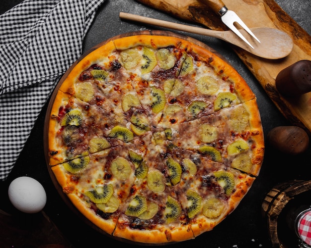 Torta di frutta con kiwi, banana e frutti di bosco.