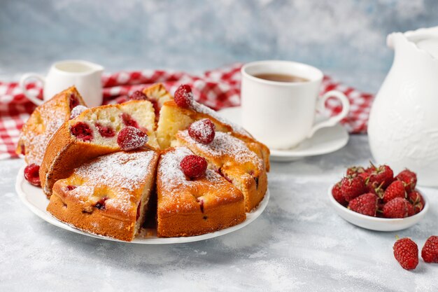 Torta di lamponi con zucchero a velo e lamponi freschi su una luce. Dessert di bacche estive.