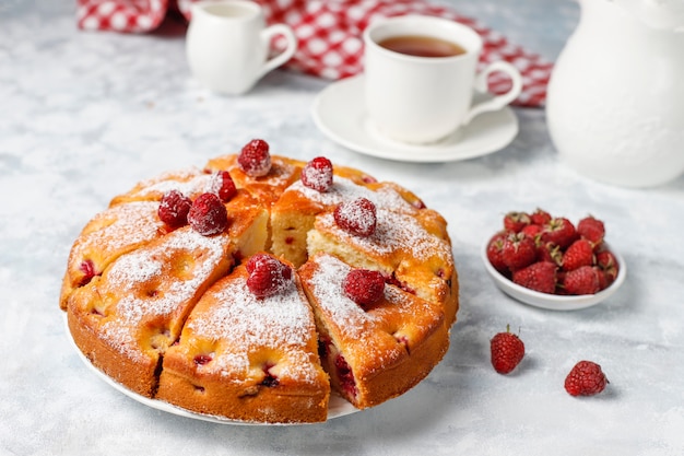 Torta di lamponi con zucchero a velo e lamponi freschi su una luce. Dessert di bacche estive.