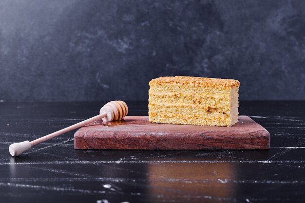 Torta di miele con cannella e frutta sulla zolla bianca accanto al tè.