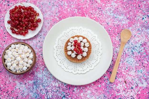 Torta di vista superiore con mirtilli rossi insieme a mirtilli rossi freschi sullo sfondo colorato dolce cuocere il colore dello zucchero della torta