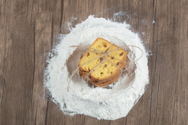 Torta dolce con ingredienti sulla tavola di legno.