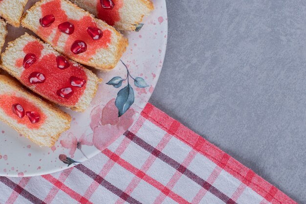 Torta fresca fatta in casa con semi di melograno sulla zolla bianca