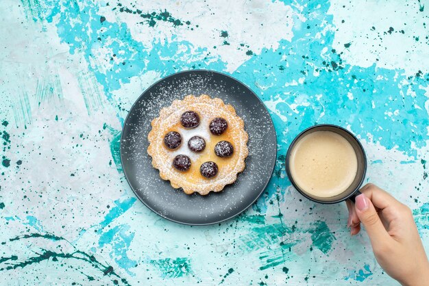 Torta in polvere di zucchero con vista dall'alto con frutta e latte sulla foto a colori del biscotto di zucchero della torta della scrivania blu