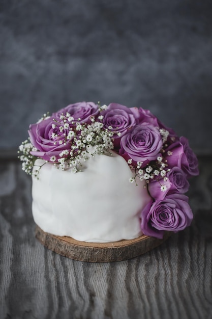 Torta nuziale rustica con rose e deco sul piatto. Avvicinamento