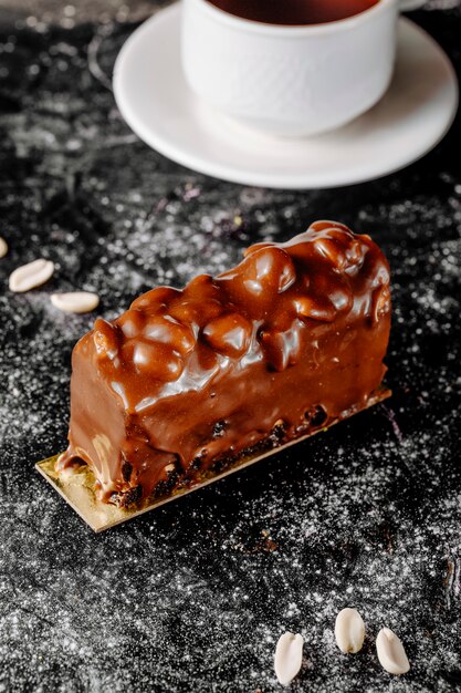 Torta ricoperta di cioccolato e arachidi sul tavolo