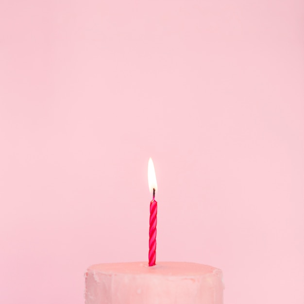 Torta rosa con candela accesa